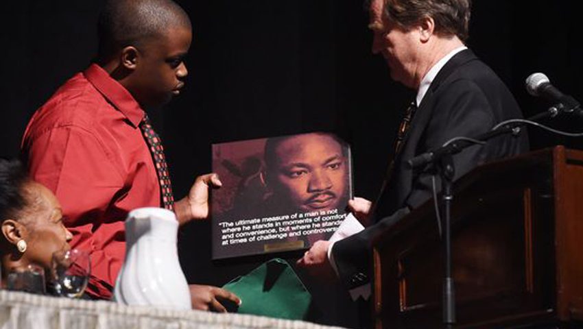 person accepting plaque with martin luther king jr.'s quote