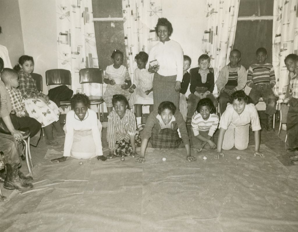 black and white image of Inside the original building at 69 Catharine Street with students and a teacher